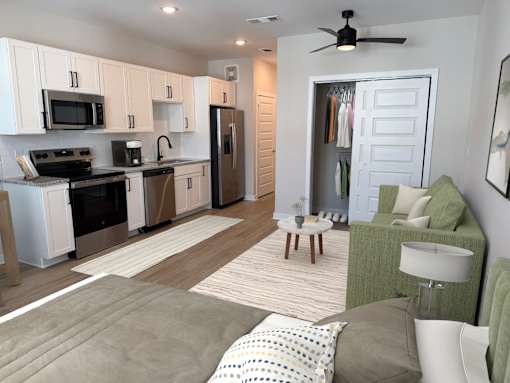 A modern kitchen with a refrigerator, microwave, and oven.