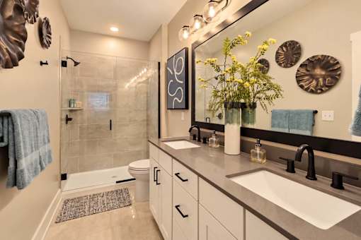 A bathroom with a sink, mirror, and shower.