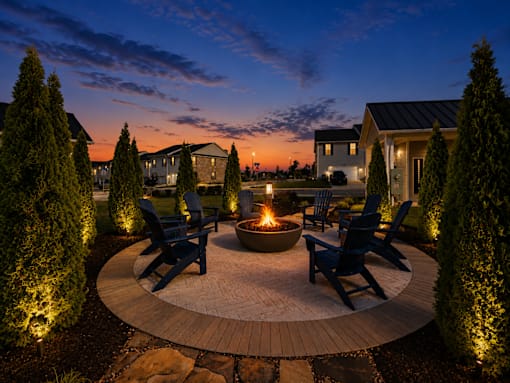 A backyard with a fire pit and chairs.
