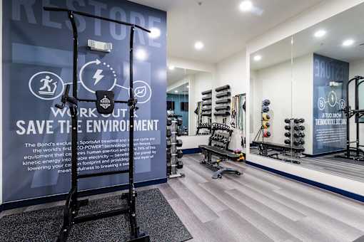 A gym with a sign that says "Restore" and a wall with a sign that says "Workout Save the Environment".