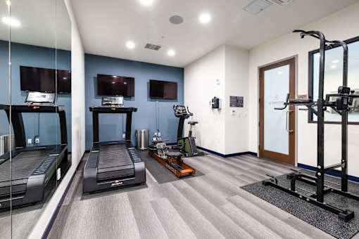A spacious gym with treadmills, exercise bikes, and a weight machine.