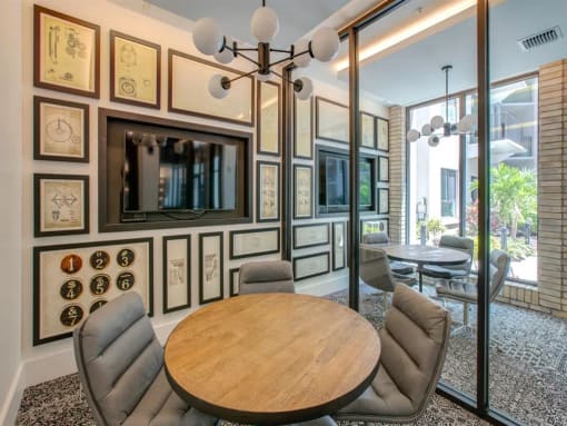 a dining room with a table and chairs and a tv on the wall at Altis Grand Central, Tampa, FL