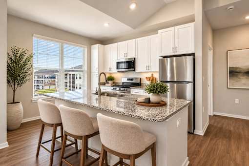 A kitchen with a granite countertop and bar stools.