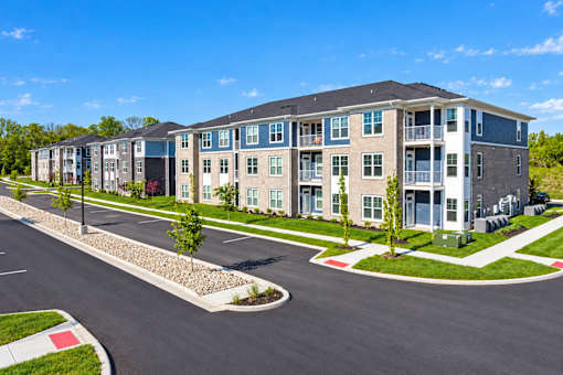 A large apartment complex with a parking lot in front.