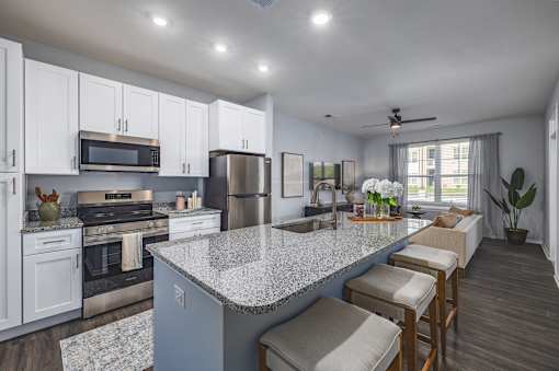 A kitchen with a granite countertop and stainless steel appliances.