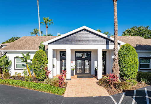 A house with a grey roof and white walls has a black front door.
