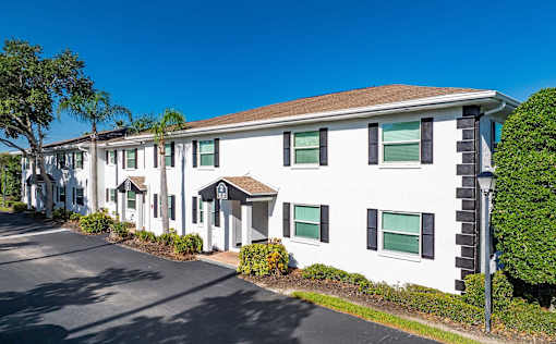 A white building with black shutters and a brown roofl at Fountains of Largo, Largo, 33774