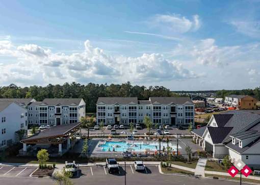 A large white building with a pool in front of it.