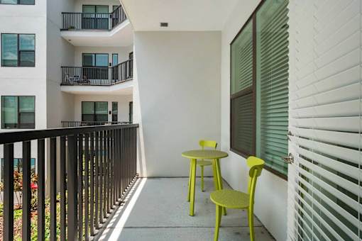 A balcony with a table and chairs.