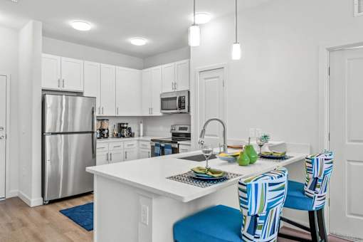 A kitchen with a white counter and blue chairs.