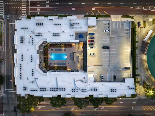 A large white building with a pool in the middle.