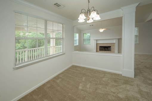 A room with a fireplace and a window with blinds.