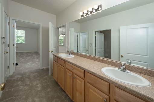 A bathroom with a sink, mirror, and cabinets.