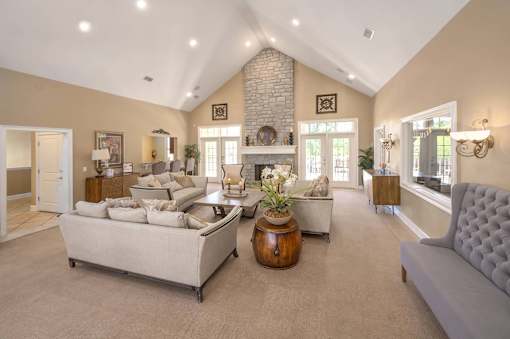 A living room with a white couch, a wooden coffee table, and a fireplace.