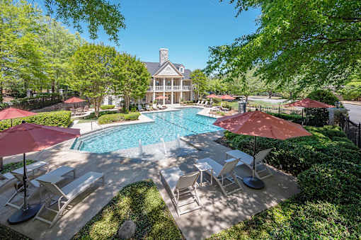 A large house with a pool and patio furniture.
