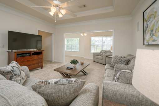 A living room with a grey couch and a wooden coffee table.