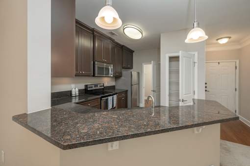 A kitchen with a granite countertop and white cabinets.