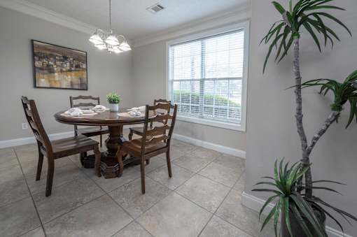 A dining room with a wooden table and chairs.