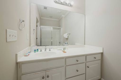 A white bathroom vanity with a mirror and lights above it.