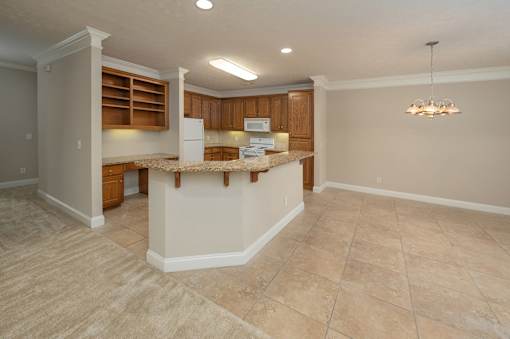 A kitchen with a white refrigerator and wooden cabinets.