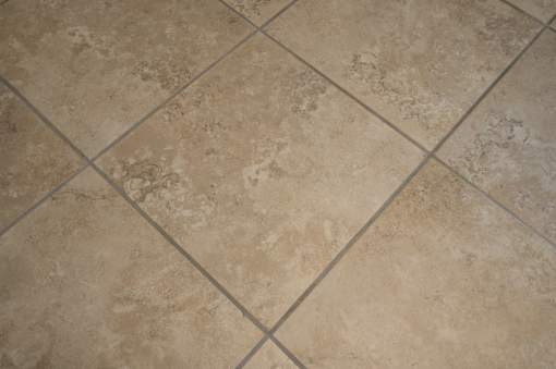 A tile floor with a beige and brown pattern.