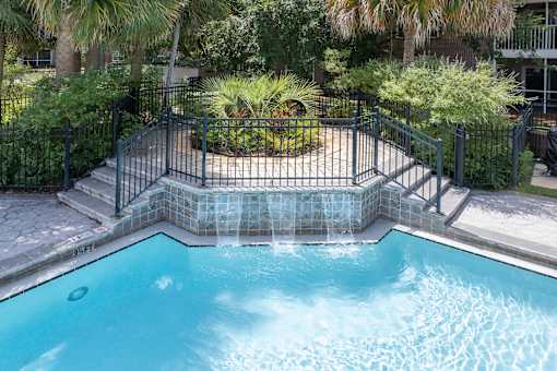 A small pool surrounded by a black fence.
