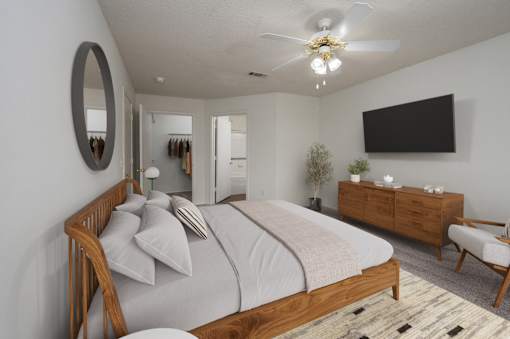 A bedroom with a large bed, a TV, and a chair.