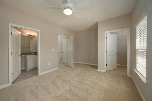 A room with a ceiling fan and a carpeted floor.