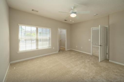 A room with a ceiling fan and a door.