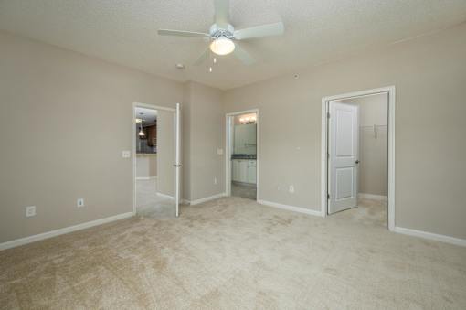 A room with a ceiling fan and carpeted floor.