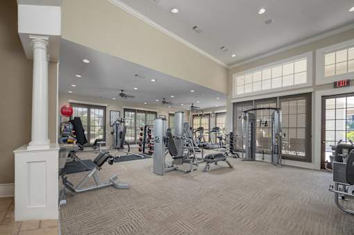 A gym with a variety of equipment including treadmills, weights, and exercise machines.