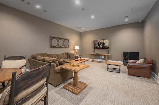 A living room with a brown couch, a wooden table, and a fireplace.