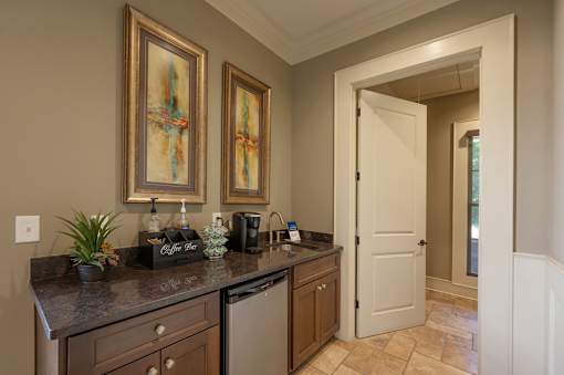 A kitchen with brown cabinets and a black counter top.