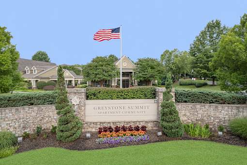 The sign in front of the building says "Greystone Summit Apartment Community".