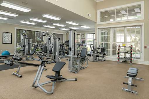 A spacious gym with a variety of equipment including treadmills, weight machines, and free weights.