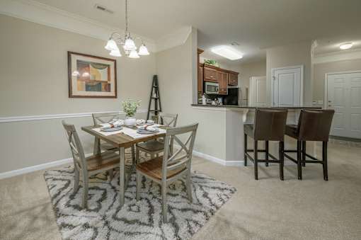 A dining room with a table set for four.