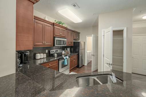 A kitchen with brown cabinets and a black refrigerator.