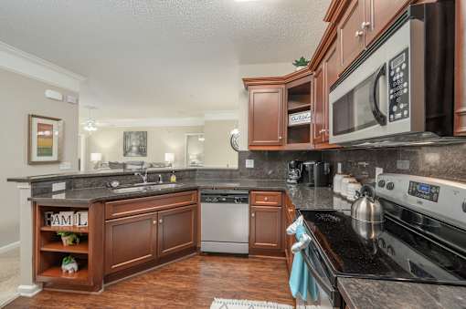 A kitchen with a black counter top and a black stove top oven.
