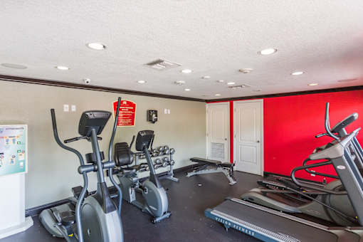 A gym with treadmills, elliptical machines, and other exercise equipment.