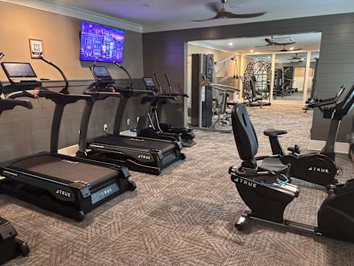 A gym with treadmills and a television.