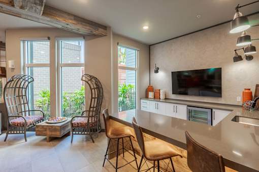 A modern kitchen with a bar area and chairs.