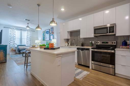 A modern kitchen with white cabinets and stainless steel appliances.