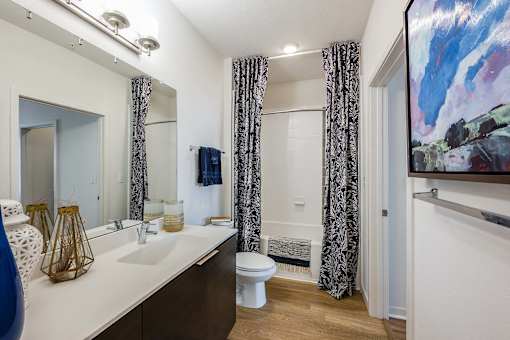 A bathroom with a white countertop and a white toilet.