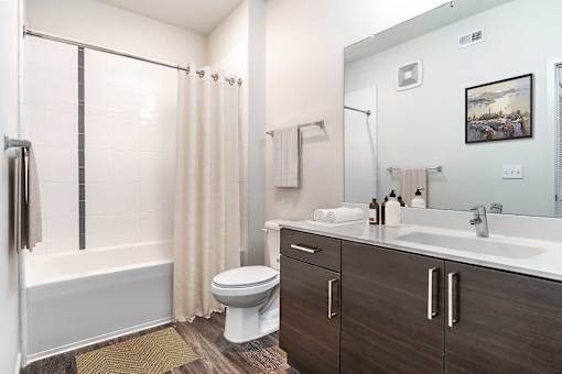 A bathroom with a white tub, sink, and toilet.