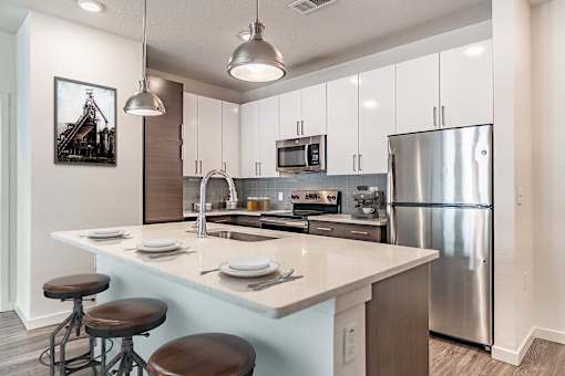 A modern kitchen with a large island and stainless steel appliances.