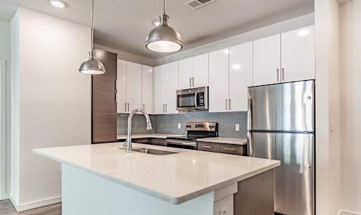 A modern kitchen with a large island and stainless steel appliances.
