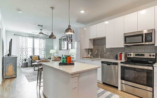A kitchen with white cabinets and a white island.