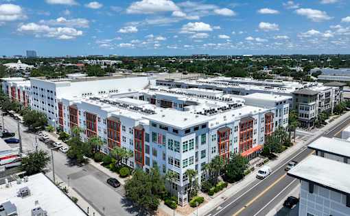 A large multi-story building with a parking lot in front.