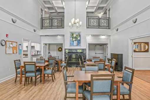 a large dining room with tables and chairs and a fireplace