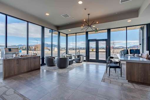 A spacious lobby with a bar area and a view of the outdoors through large windows.